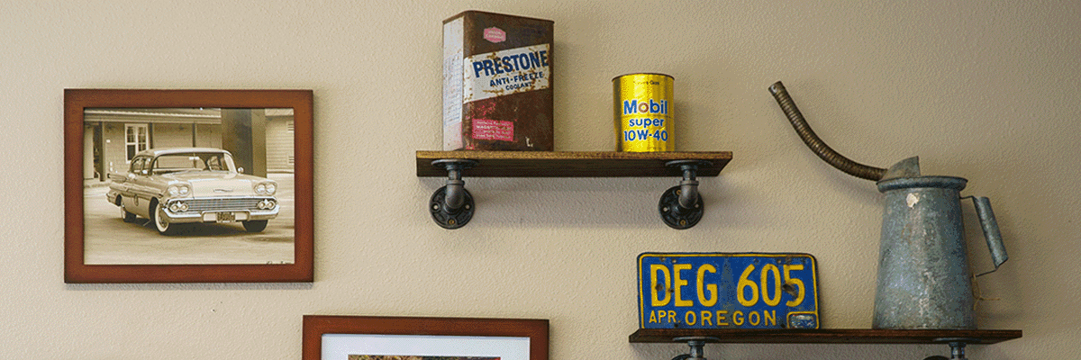 Vintage tin oil cans, Prestone and Mobil cans, oil pitcher, and an Oregon license plate on the shop wall
